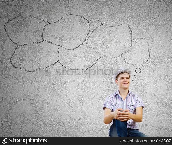 Young smiling man. Young man in casual sitting and thinking. Creativity concept