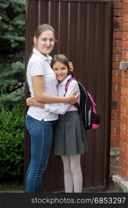 Young smiling mother seeing off her daughter to school