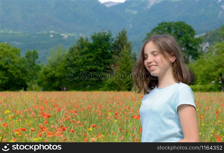 Young smiling teenager girl in poppy field