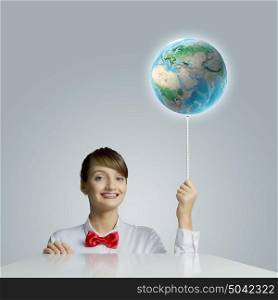 Young smiling woman holding balloon colored like Earth planet. Elements of this image are furnished by NASA. Ecology concept