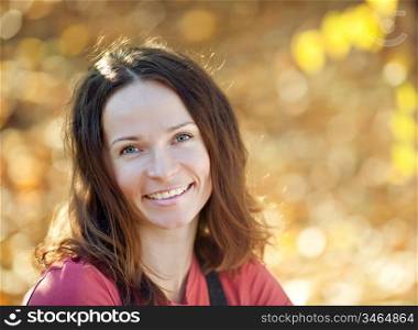 Young smiling woman in autumn park
