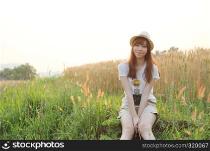 Young smiling woman in field with wheat