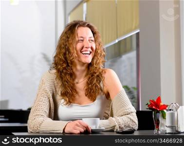 young smiling woman is sitting at cafe