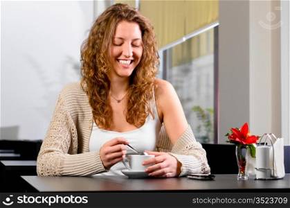young smiling woman is sitting at cafe