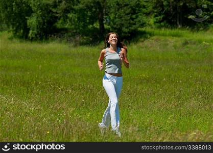 Young smiling woman jogging in the nature, shallow DOF