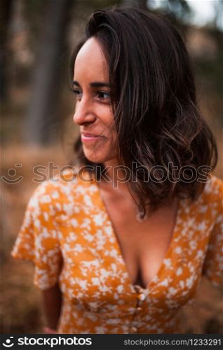 Young smiling woman wearing dress in the forest