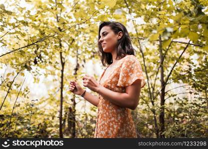 Young smiling woman wearing dress in the forest
