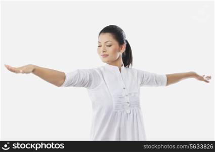 Young smiling woman with arms outstretched over white background