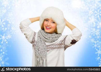 Young smiling woman with fur hat on blue snowy background