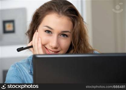 young smiling woman with long hair is using a laptop