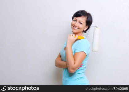Young smiling woman with painting roller