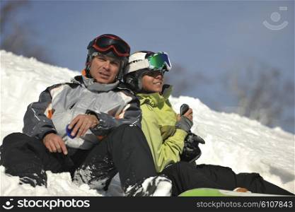 young snowboarders couple relaxing and enjoy on sunny winter day on fresh snow