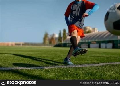 Young soccer goalie starting game kicking ball from white goal line. Football tournament or training for children concept. Young soccer goalie starting game kicking ball from white goal line
