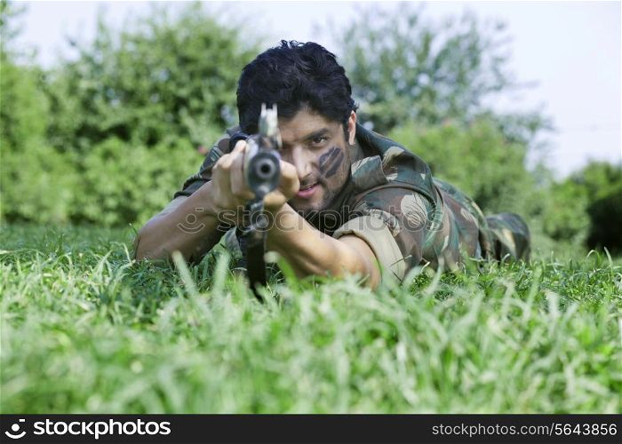Young soldier aiming with rifle
