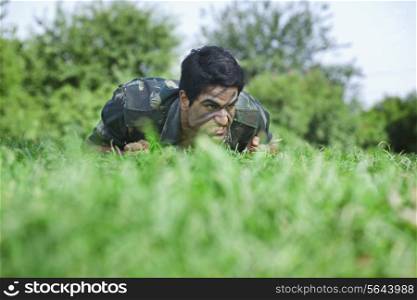 Young soldier crawling on field