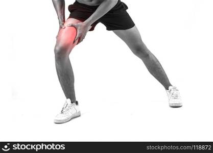 Young sport man with strong athletic legs holding knee with his hands in pain after suffering ligament injury isolated on white.. Young sport man with strong athletic legs holding knee with his
