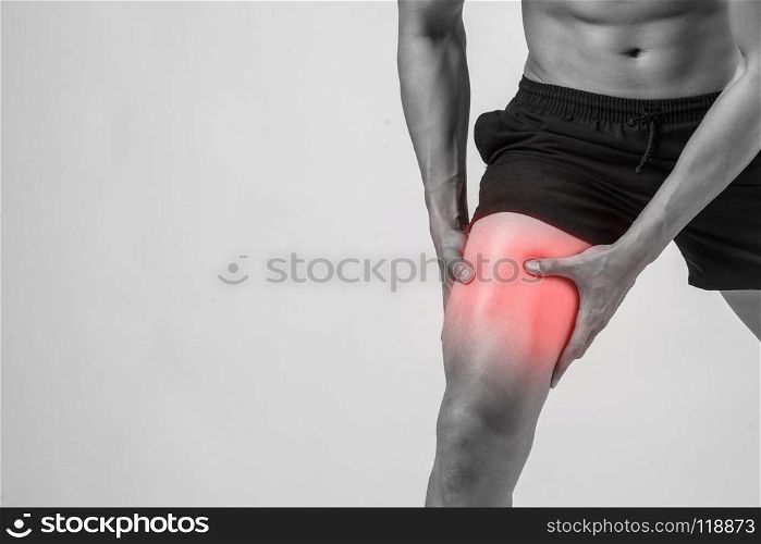 Young sport man with strong athletic legs holding knee with his hands in pain after suffering ligament injury isolated on white.. Young sport man with strong athletic legs holding knee with his