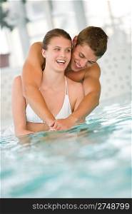 Young sportive couple have fun in swimming pool in luxury hotel