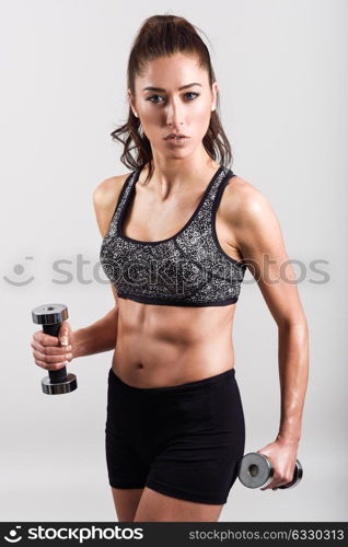 Young sports sexy fitness woman body with dumbbells posing on white background.