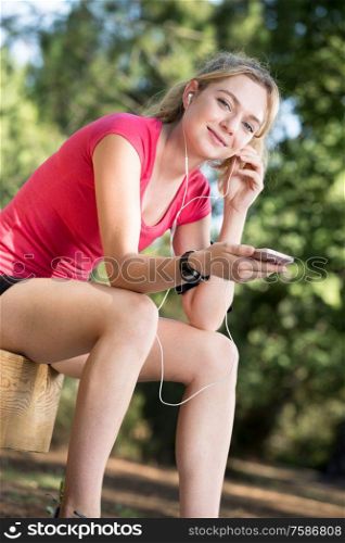 young sports woman outdoors listening music