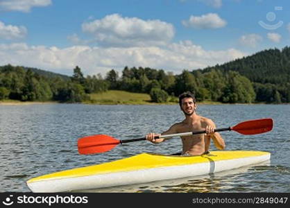 Young sportsman kayaking on sunny day on lake