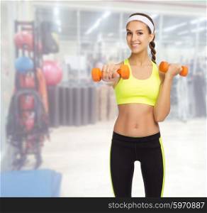 Young sporty girl with dumbbells in fitness club