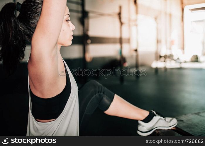 Young sporty woman stretching in interior before exercise