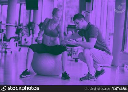 young sporty woman with trainer exercise weights lifting. young sporty woman with trainer exercise weights lifting in fitness gym duo tone