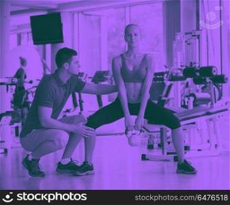 young sporty woman with trainer exercise weights lifting. young sporty woman with trainer exercise weights lifting in fitness gym duo tone