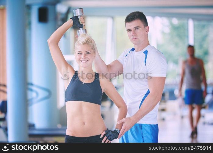 young sporty woman with trainer exercise weights lifting in fitness gym. young sporty woman with trainer exercise weights lifting