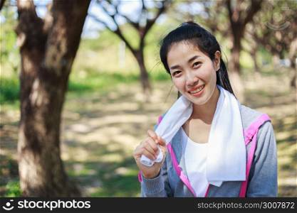 young sporty woman with white towel resting after workout sport exercises outdoors at the park