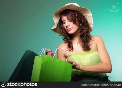 young spring woman with shopping bags on green background