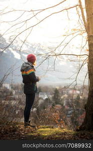 Young standing girl is enjoying the sunset scenery, winter time