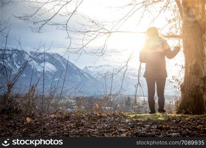 Young standing girl is enjoying the sunset scenery, winter time