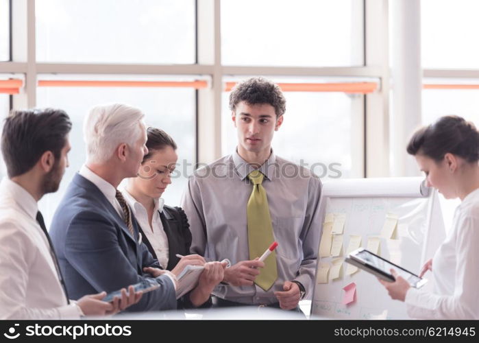 young startup businessman making presentation of project to senior investior, group of business people taking notes and make plans on white flip board and tablet computer