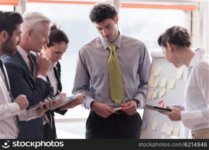 young startup businessman making presentation of project to senior investior, group of business people taking notes and make plans on white flip board and tablet computer