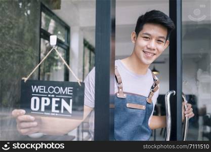 Young startup coffee cafe owener open and welcome customer. New small business owener.