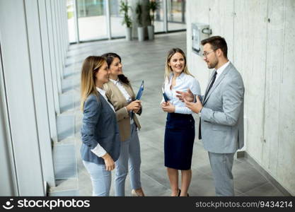 Young startup team have a discussion by the stairs in the office corridor