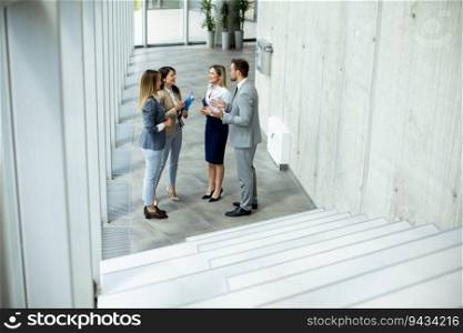 Young startup team have a discussion by the stairs in the office corridor