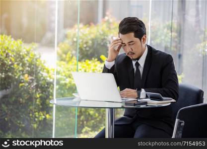 young stressed business man using laptop and working problem