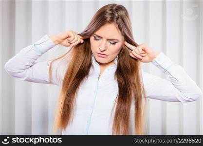 Young stressed female handling emotions cover ears. Woman with migraine avoid noise in office.. Stressed woman with closed eyes put fingers in ears,