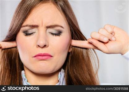 Young stressed female handling emotions cover ears. Woman with migraine avoid noise in office.. Stressed woman with closed eyes put fingers in ears,