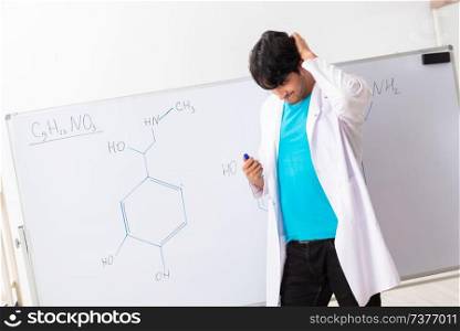 Young student chemist in the classroom 