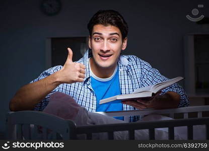 Young student doing homework and looking after newborn baby