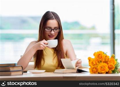 Young student drinking coffee while sudying