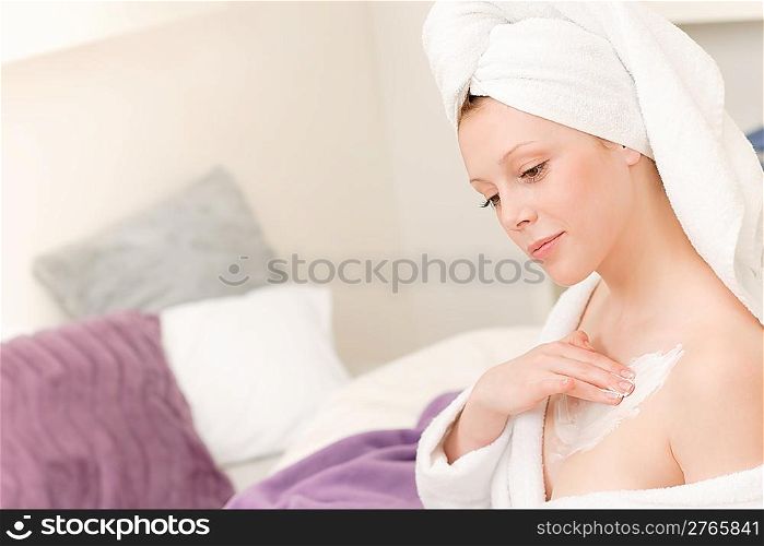 Young student girl apply body cream lotion on her chest on her chest
