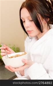 Young student girl eat cereal for breakfast wear bathrobe