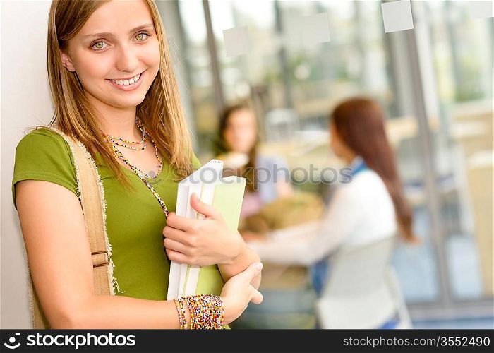 Young student girl holding book standing posing at high school