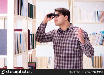 Young student looking for books in college library