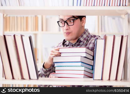 Young student looking for books in college library